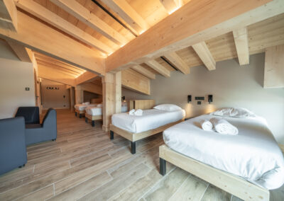 Une chambre avec deux lits et poutres en bois.
