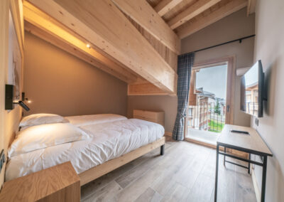 Une chambre avec un plafond en bois et un lit.